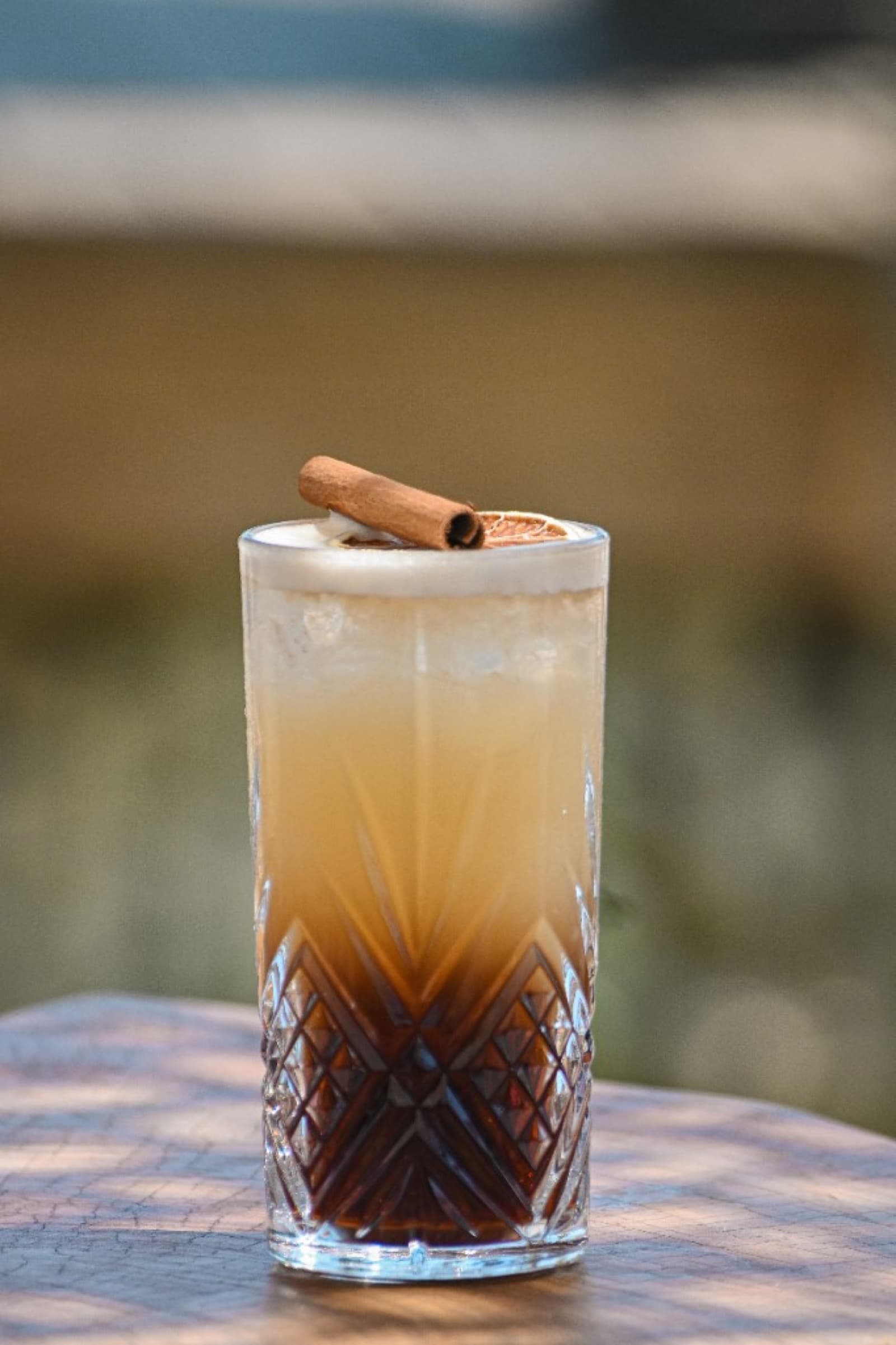 Cocktail signature en verre texturé — cannelle et agrumes séchés, bar La Paillote Paradise